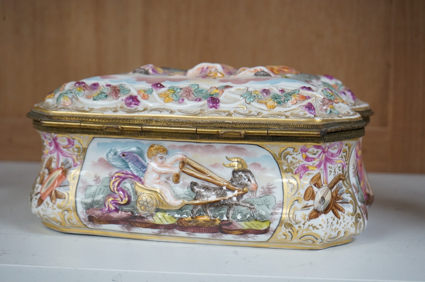 An ornate Neapolitan Capodimonte porcelain box with gilt mounts, 22cm wide, 11cm high